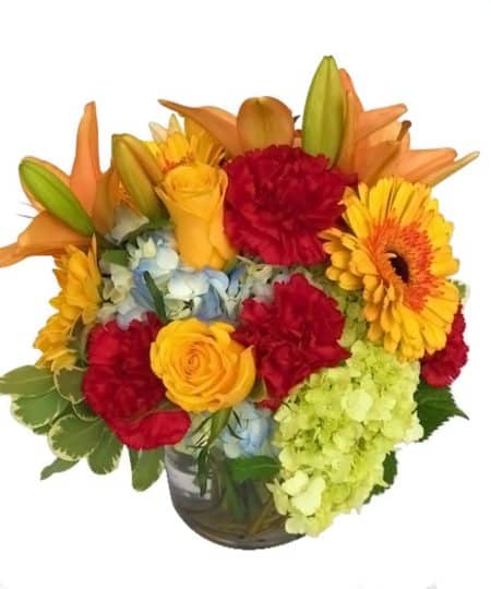This bouquet is blooming with vibrant colors to bring a smile and delight to the face of that special recipient. Roses, gerbera daisies, hydrangea and lilies are nestled together to create this colorful bouquet